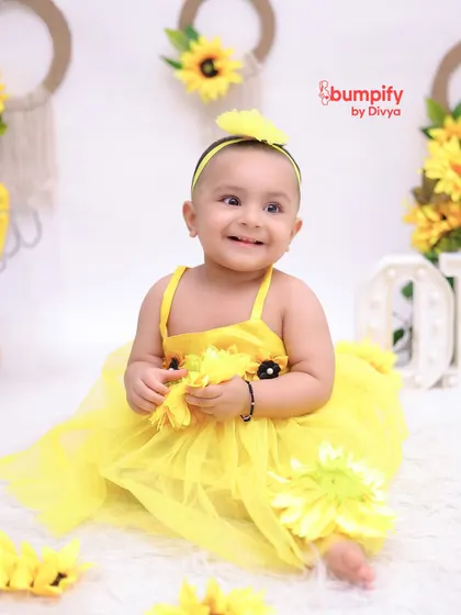 Our little sunshine. This baby girl is all smiles during her sunflower themed first birthday photoshoot. The bright yellow dress and flowers create such a happy, vibrant image.