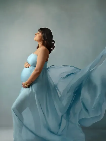Feeling the breeze. This pose with the flowing blue fabric captures a sense of freedom and release.