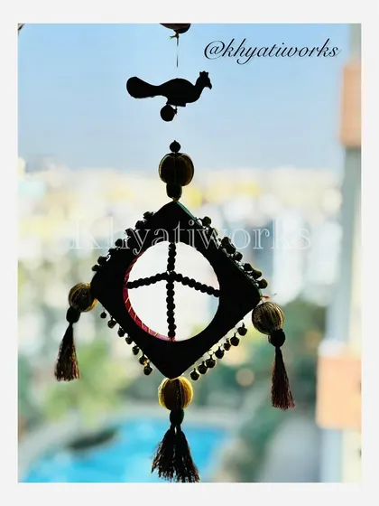 A silhouette of the kite hanging against a window. Even without seeing the colors, the unique shape and the little bird on top stand out.