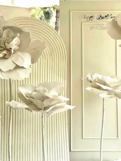 A minimalist and modern birthday backdrop with giant white paper flowers.