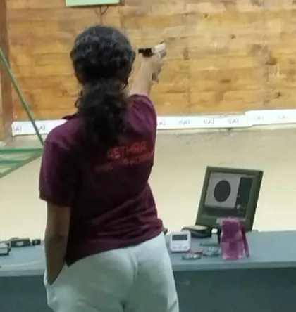 A student wearing our academy T-shirt competes in the 12th Karnataka State Sport Shooting Championship, with her shot displayed on the monitor.
