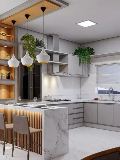 This L-shaped kitchen includes a breakfast bar with fluted paneling and stylish pendant lights. The open shelves above the counter add a decorative and functional touch.