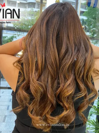A beautiful example of a warm, honey-toned balayage on long hair. The color looks especially vibrant in the natural light, giving it a healthy, glossy finish.