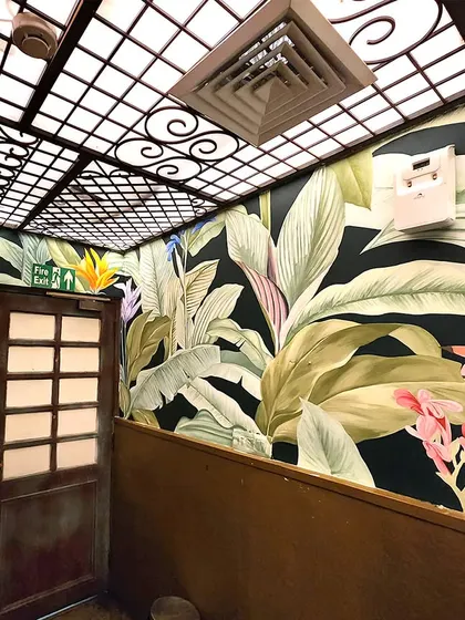 Another view of The Drunken Botanist washroom, showing how the mural wraps around the entire space, creating a cohesive and transportive experience.