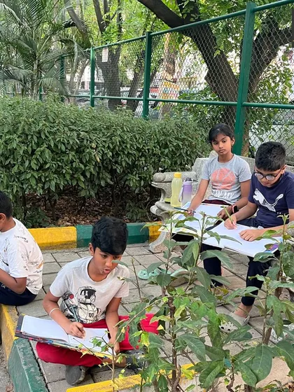 A group of young artists fully engaged in an outdoor sketching session. Learning to observe and draw from life is a critical skill that I encourage at every level.