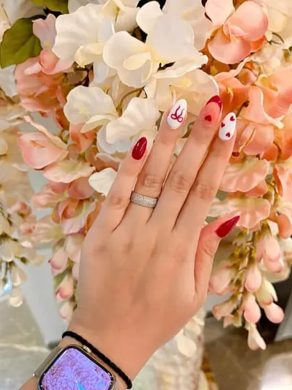A full view of this lovely, hand-painted red and white heart-themed manicure.