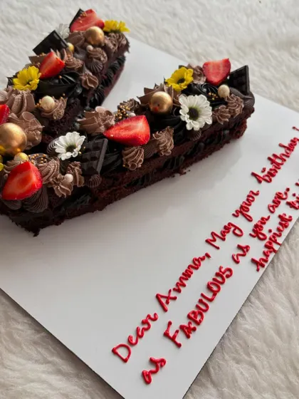 Letter cakes are a great way to personalize a celebration. This is a 'V' shaped chocolate cake, decorated with fresh strawberries, flowers, and chocolate details for a fabulous birthday.