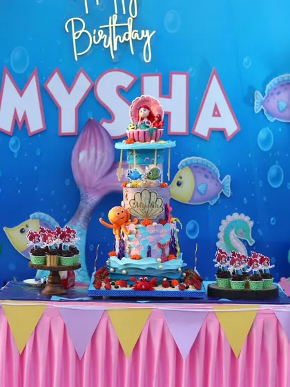 The complete dessert table with the cake and matching Ariel cupcakes.