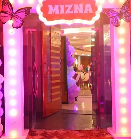 A grand lighted entrance for a butterfly-themed first birthday party. The pink lighting and butterfly accents create a magical welcome for the guests.