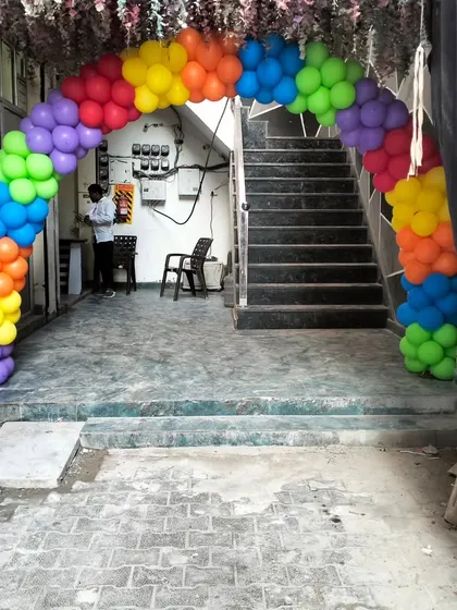 A rainbow balloon arch at the entrance of a home, setting the stage for a colorful Cocomelon party inside.