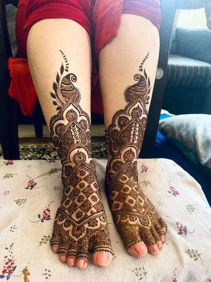 A gorgeous and dense foot design featuring paisley and peacock elements with intricate jaali work. This style provides full coverage for a dramatic bridal look.