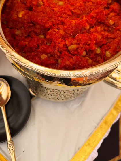 No Indian celebration is complete without a classic dessert. Here is our rich and flavorful Gajar ka Halwa, slow-cooked to perfection and served warm in an ornate silver serving bowl, perfect for a wedding feast.