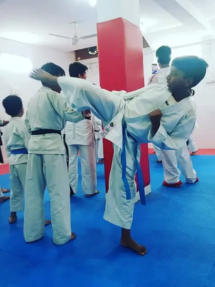 A young student practices a high kick during the seminar, showing great potential and focus.