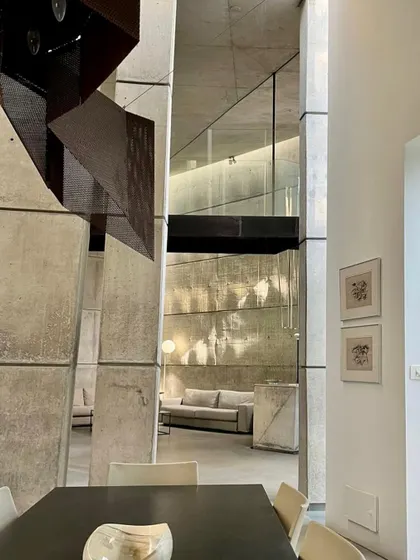 A view from the dining area across the main hall in the 'House of Stories'. The design uses overlapping volumes and a bridge to create a complex interior landscape, where spaces are distinct yet visually connected.