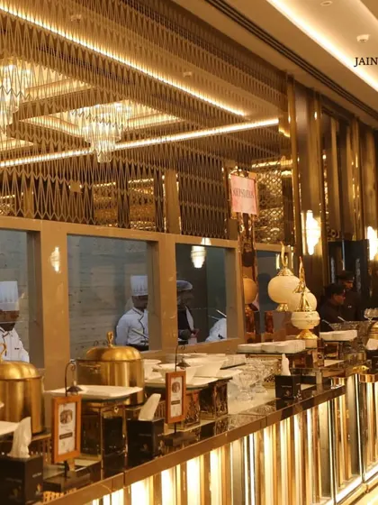 A stunning, gold-themed buffet line under magnificent chandeliers at one of our premium banquet hall partners.