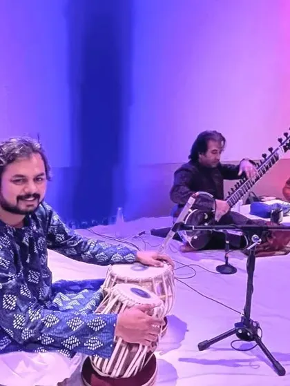 A colorful stage photo with Ustad Rafique Khan and Sarfaraaz Khan.