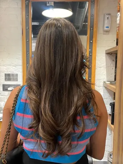 The back view showcases the full effect of the no-bleach highlights, adding dimension throughout the lengths of her hair.