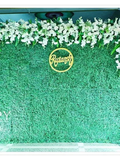 A full view of the greenery backdrop featuring the golden name cutout "Rutansh". The simple design makes the name the star of the show.