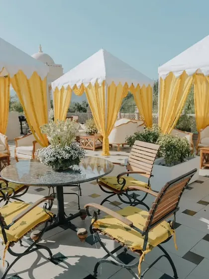 An elegant rooftop seating area with yellow-draped cabanas for a Haldi ceremony. We create comfortable and stylish spaces for guests to relax and enjoy the festivities.
