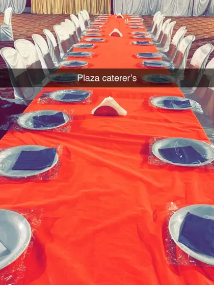 A clean and simple table setup before the food is served. Each spot is ready with a plate and napkin, showing our organized approach to event preparation.