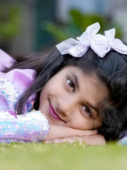 A beautiful close-up portrait of an older girl lying on the grass. We capture the unique beauty of children at every age.