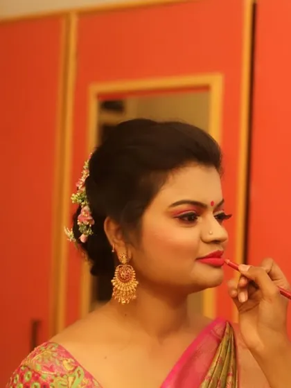 The final touch. In this photo, I am carefully applying lipstick for a client's reception look. A precise lip line is essential for a polished and long-lasting finish.
