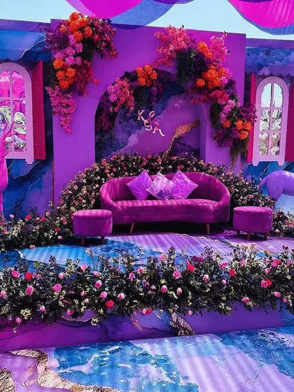 A whimsical, fantasy-themed stage in shades of purple, complete with deer props and an abundance of flowers.