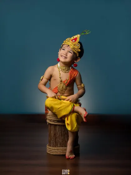 A joyful, eyes-closed smile from our little Krishna.