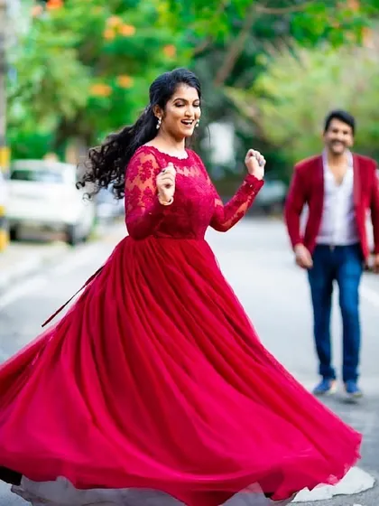 A moment of pure joy and dance. This deep red gown with delicate lace sleeves is perfect for capturing candid, happy moments during a pre-wedding or post-wedding shoot.