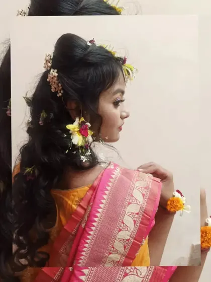 This side profile captures the harmony between the makeup, the fresh flower earrings, and the soft hairstyle. Our training emphasizes creating a cohesive and balanced look for the client.