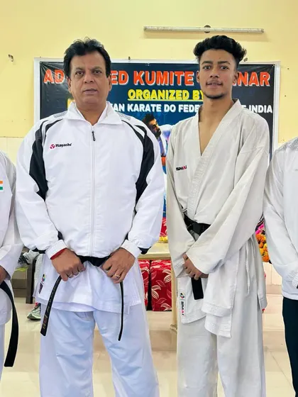 My student with Hanshi Bharat Sharma and other senior instructors. The guidance from these masters is essential for developing the next generation of champions.