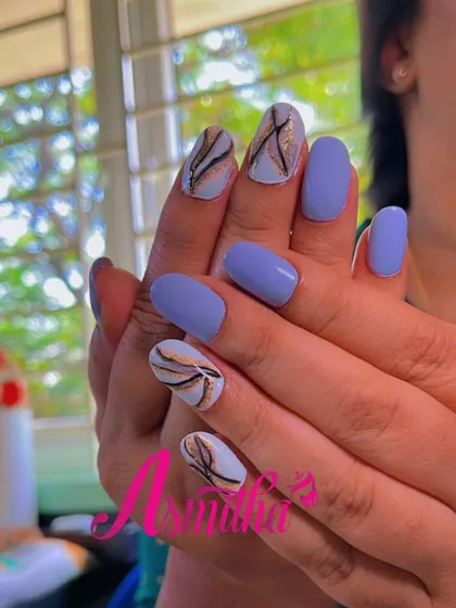 This angle highlights the abstract, leaf-like strokes of the black and gold marble design on the white accent nails.