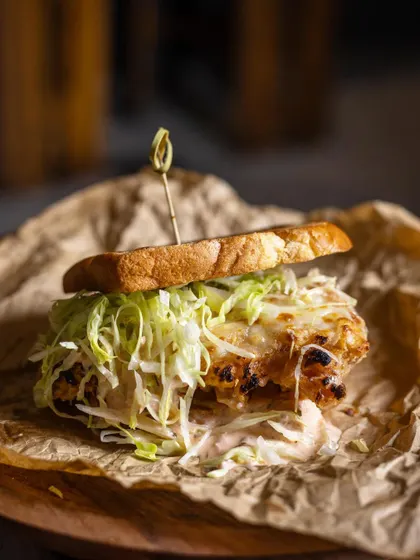 The ultimate buttermilk chicken sandwich. Juicy, crunchy, smoked, and tender, it's served on rustic paper for a casual, delicious meal.
