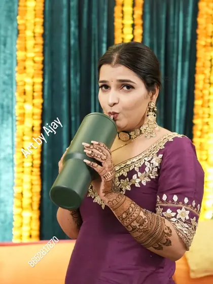 A fun, candid shot of a bride staying hydrated during her mehndi ceremony. Her beautiful henna is on full display.