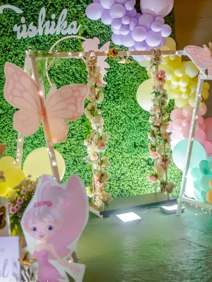 I created an enchanted butterfly garden with a floral-decorated swing against a green wall. The space was filled with pastel balloons and large butterfly cutouts to create a whimsical photo area.