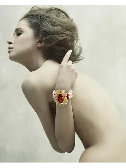 A fine art approach to jewellery photography from the "Sculptured Portraits" series. The model's pose is sculptural, turning the body into a canvas to display the intricate, gem-studded bracelet.