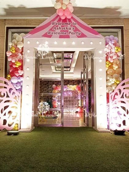 A welcoming entrance for a butterfly-themed party, featuring a house-shaped arch with butterfly wing details and bright, cheerful lighting.