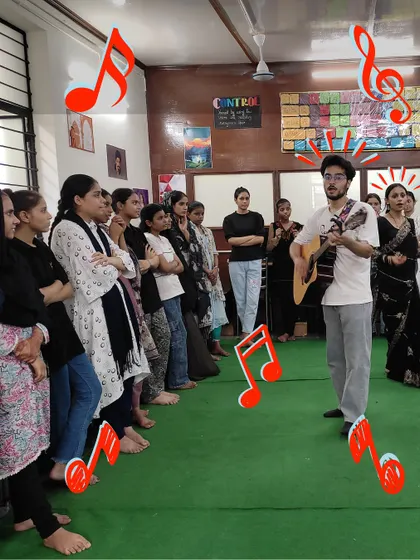 A fellow plays guitar for a group of students in a community center. These sessions combine music with play and reflection, helping children grow in confidence, focus, and self-expression.