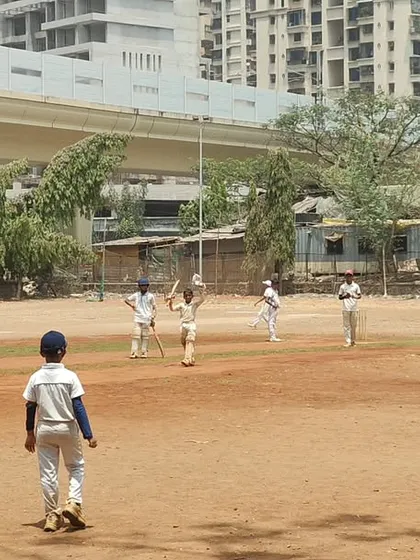 A young wicketkeeper batsman holds his ground during a competitive match. We train our players to build long innings and develop the temperament needed for real match situations.
