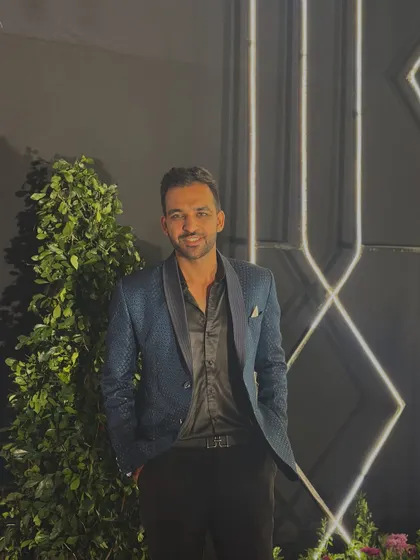 A smiling shot in my blue sequined blazer. I believe in looking good and feeling good to deliver the best performance for my clients.