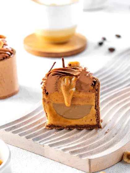 A cross-section of a hazelnut mousse dessert, revealing the gooey, multi-layered interior. This detailed shot is designed to make the viewer crave the rich combination of flavors and textures inside.