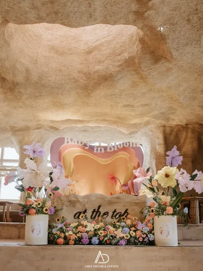 Let's bring your most whimsical ideas to life. This "Baby in Bloom" themed baby shower, set in a unique cave-like venue, features a custom heart-shaped backdrop and oversized paper flowers for a playful and unforgettable party.