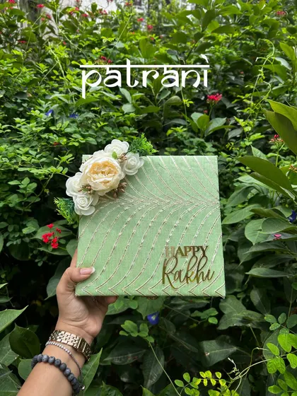 The 'Patrani' hamper for Rakhi, a beautiful pastel green box filled with pistachios, sweets, and a matching bhaiya-bhabhi rakhi set.