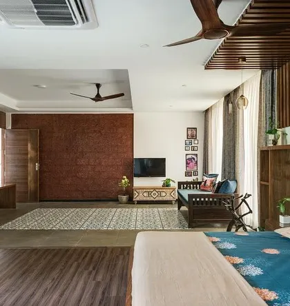 This perspective of the master bedroom highlights the laterite feature wall and the wooden slat details. These elements add texture and a connection to the local material palette, grounding the modern design.