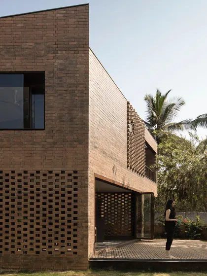(Duplicate of 40) A view of the Brick House entrance, where a large pivoting door opens into a space defined by the warmth and texture of hand-moulded brick.