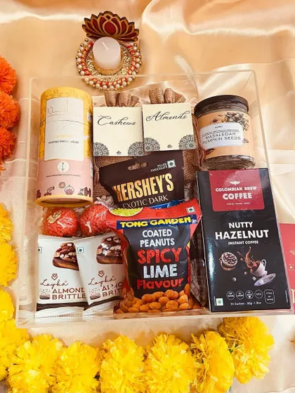 An unwrapped view of the clear acrylic tray hamper, showcasing the generous assortment of gourmet snacks and coffee.