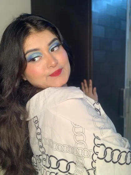 A bold look with sky blue eyeshadow and a red lip.