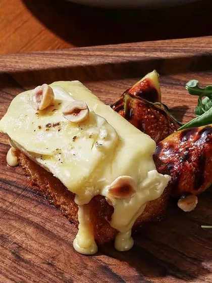 A close-up of the melted brie, figs, and hazelnuts on our popular toast, a perfect starter or light brunch plate.
