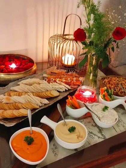 A delicious assortment of Mediterranean titbits. This platter features flatbreads, crackers, pickled veggies, and a variety of spreads like hummus and baba ganoush for a flavorful affair.