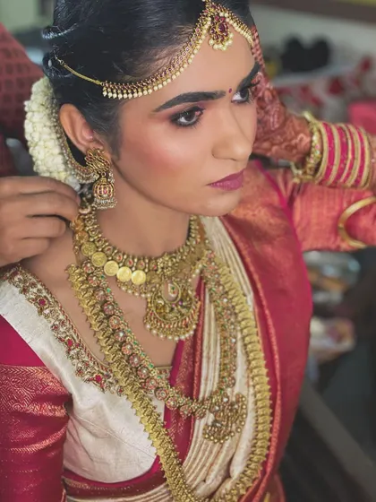A side profile showcasing the detailed eye makeup and the traditional matha patti. The look is both regal and timeless.
